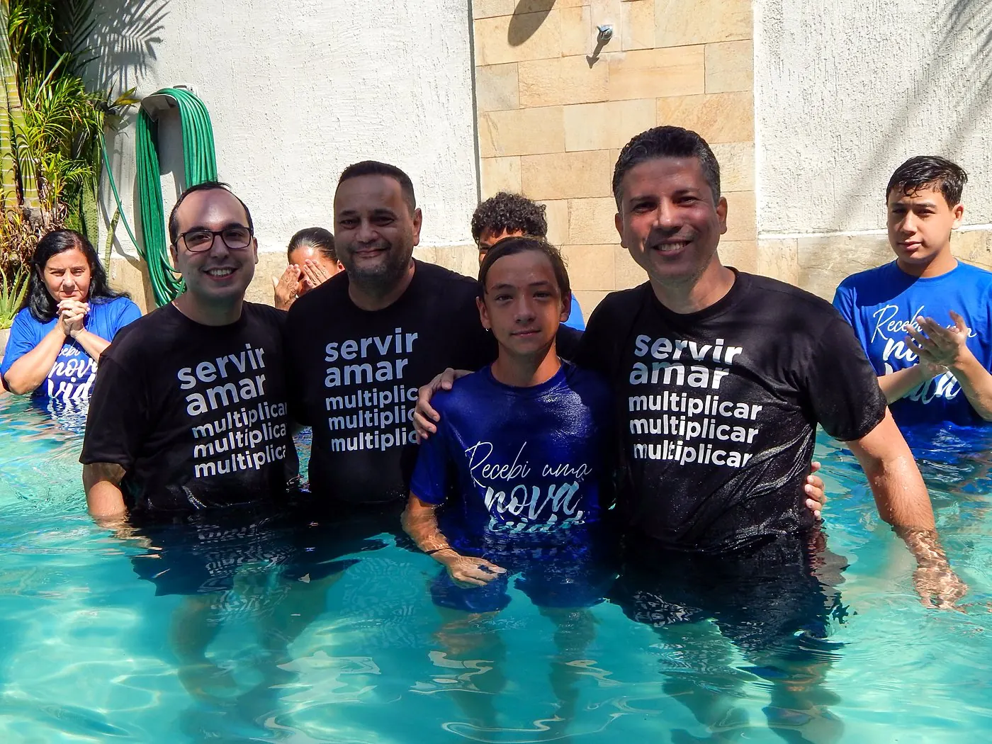 Pastores e batizando sorrindo na piscina