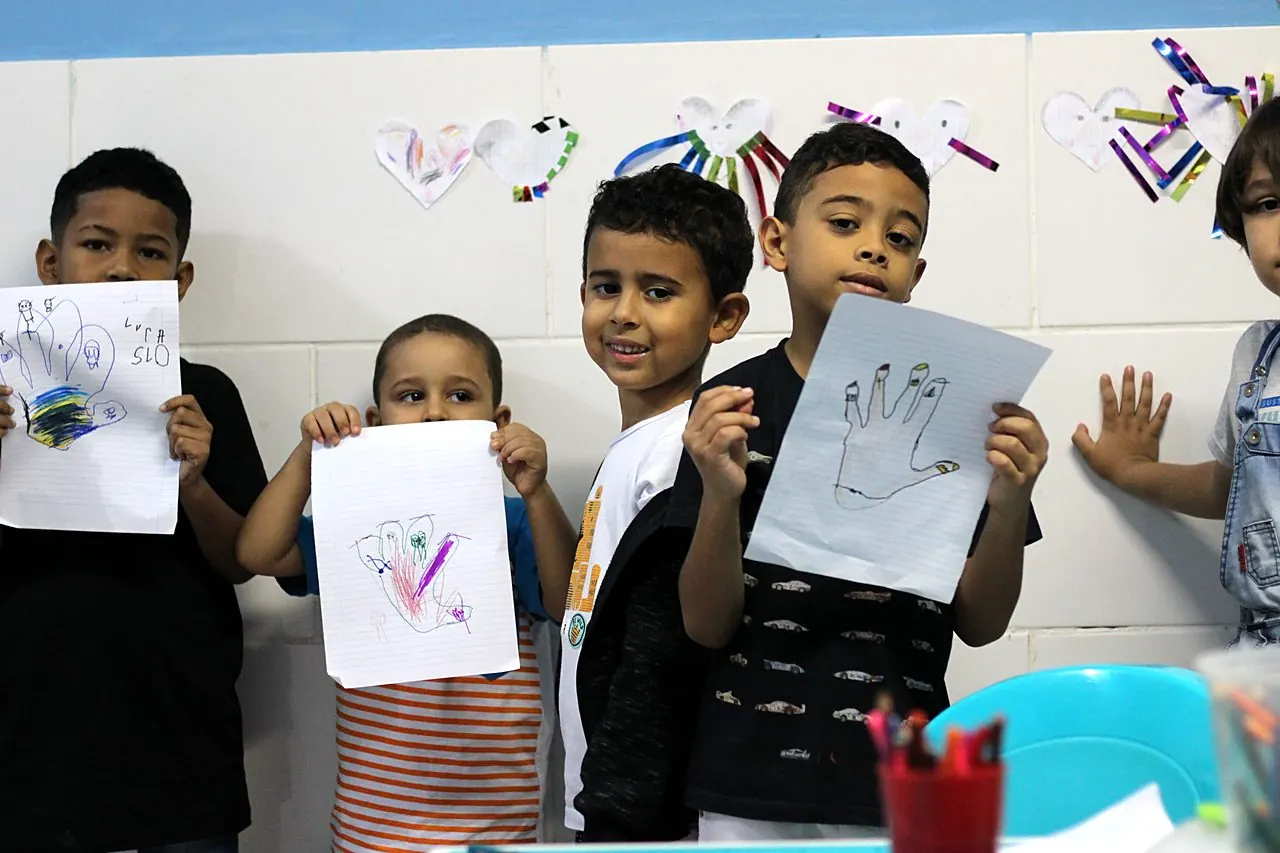 Crianças mostrando os desenhos da aula