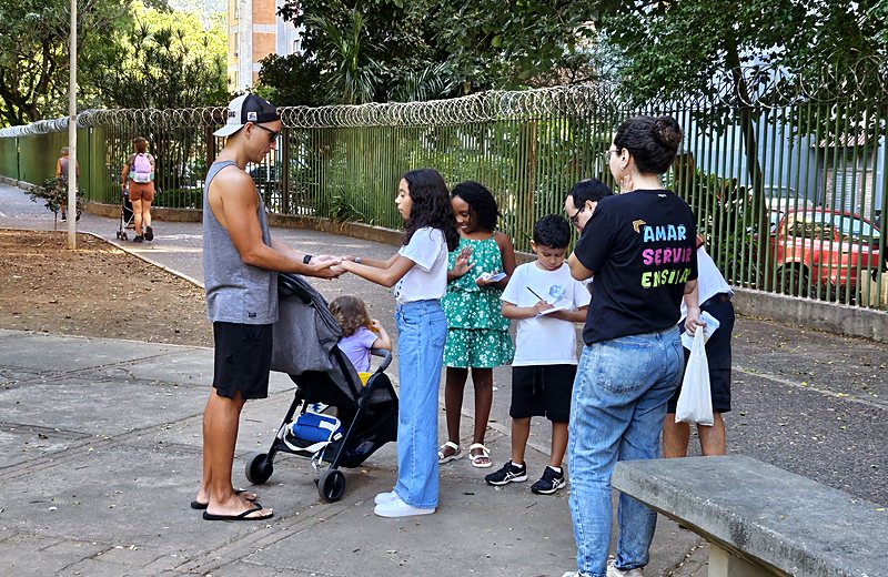 Equipe de evangelismo conversando com uma família na praça